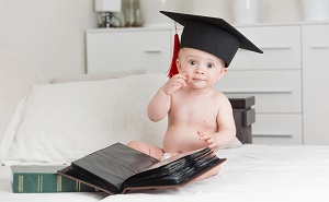 Baby sitting with a graduation cap on head